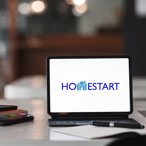 Computer with HomeStart Logo and books to the side