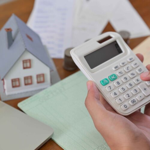 Hand is using calculator to calculate the home expenses.